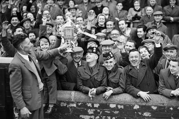 Mathie Chalmers Hearts groundsman shows the Scottish Cup to a section of the crowd at Tynecastle in 1956. Hearts had beaten Celtic at Hampden Park in the Scottish Cup final, 1956.