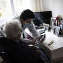 A care home worker helps an elder resident