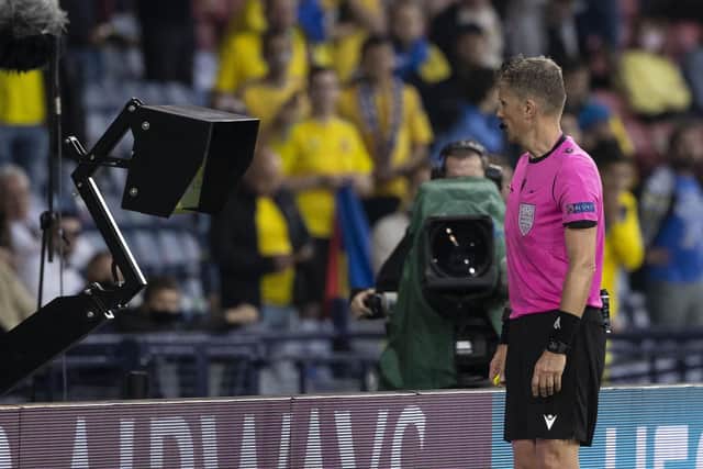 A referee checks the VAR monitor during a match - the technology could be introduced to Scottish football within the next ten days