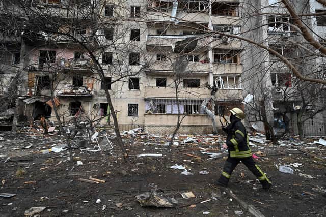 Firefighters work at a damaged residential building at Koshytsa Street, a suburb of the Ukrainian capital Kyiv, where a military shell allegedly hit, on February 25, 2022. (Photo by GENYA SAVILOV / AFP) (Photo by GENYA SAVILOV/AFP via Getty Images)