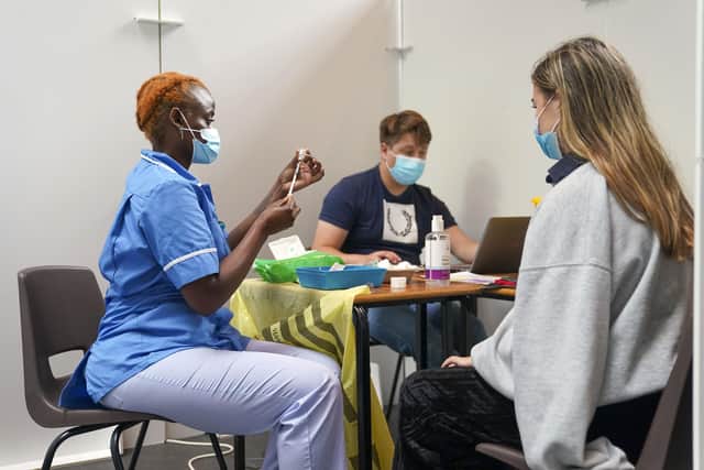 Nurse Marvis Birungi (left) gives a vaccine injection to Oxford Brookes University student Eleanor Seddon in a pop-up Vaccination clinic at the University's Headington Campus in Oxford. Unvaccinated university students have been urged to get a Covid jab in freshers' week to protect themselves and their peers against the virus. Picture date: Friday September 17, 2021.