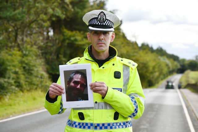 Inspector Houston holds a photograph of George Robertson at the scene of the crash. Picture: Michael Gillen/JPIMedia