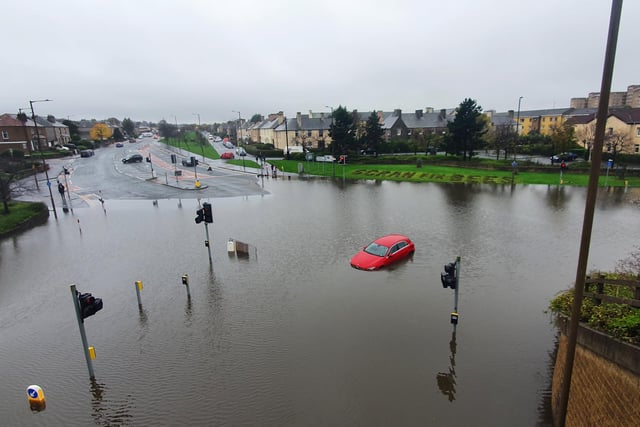 A car submerged in water covering the tyres and registration plate stranded in the middle of the junction of Ferry Road and West Granton Access Road.