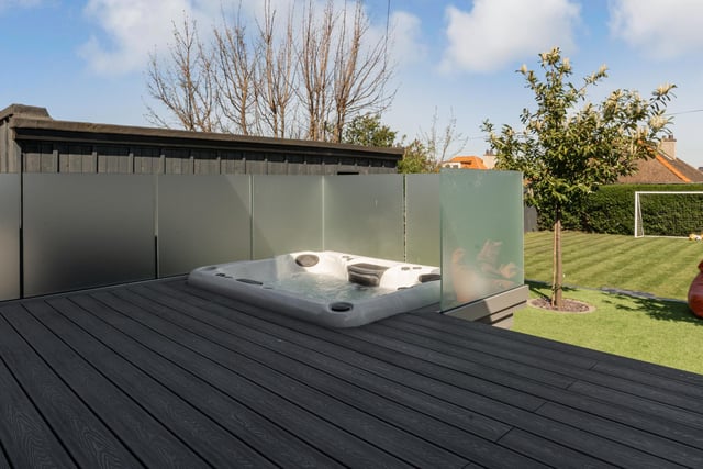 There is a stylish hot tub built into the large sundeck with steps leading down to the beautiful, landscaped garden.