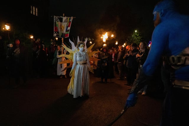 Performers dressed in stunning costumes march up Calton Hill as part of a torchlit procession.
