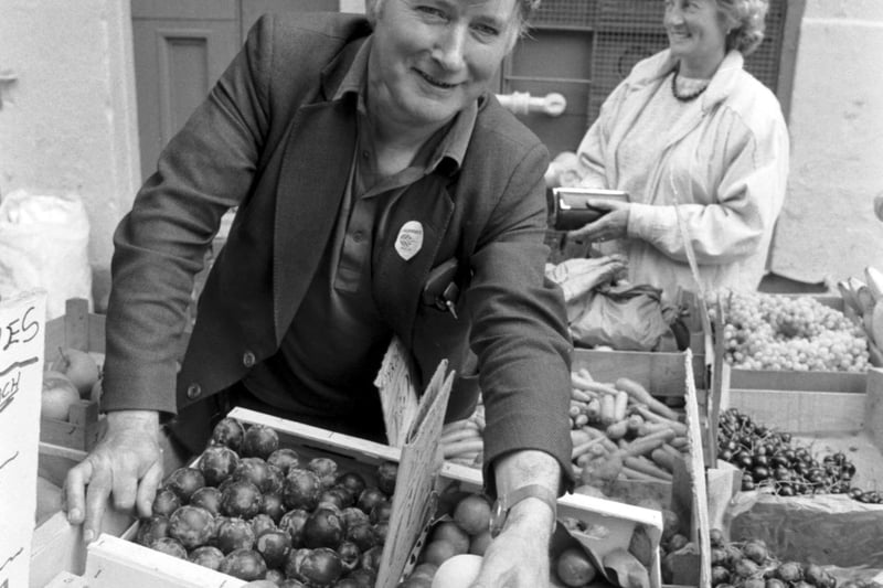 Fresh fruit and vegetable seller Willie Blues serves a customer some nectarines from his stall in Infirmary Street in Edinburgh in August 1986.