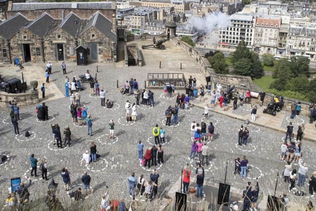 Visitors at Edinburgh Castle can be seen social-distancing while watching the one o'clock gun show.