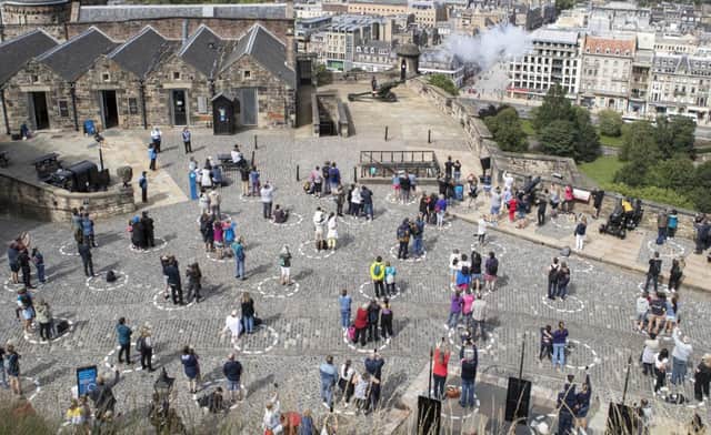 Visitors at Edinburgh Castle can be seen social-distancing while watching the one o'clock gun show.