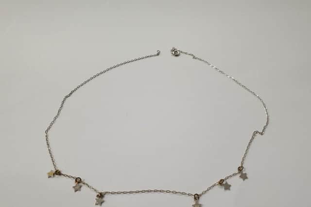 A silver chain with stars was found as the body of a woman was recovered.