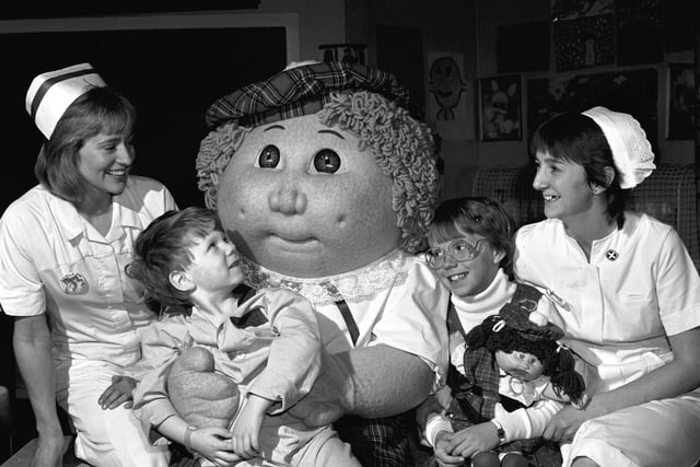 A giant Cabbage Patch Kid and 10-year-old Krisha Jacobs (with a Cabbage Patch doll) visited the Sick Children's Hospital in Edinburgh in October 1985.