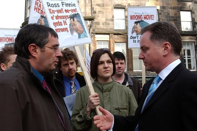 Labour First Minister Jack McConnell talks to union protesters during a campaign visit to Edinburgh. 
Albie O'Neill, a negotiator for the PCS union and staff from Scottish Natural Heritage were opposing plans to relocate SNH headquarters from Edinburgh to Inverness. 
Labour lost six seats at the election, reducing them to 50 MSPs, but Mr McConnell - who had become First Minister of the Labour-Lib Dem coalition government in November 2001- remained in office for another term before losing power narrowly to the SNP in 2007.