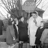 Patrol woman Mollie Harris helps children cross the road at Oxgangs in February 1962.