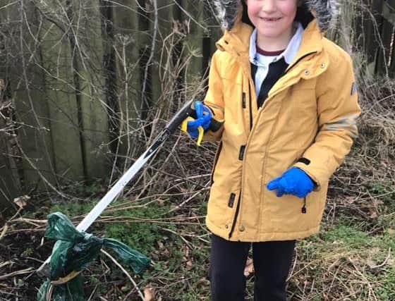 Archie Barry, seven, helping clear up the farm in Ratho.