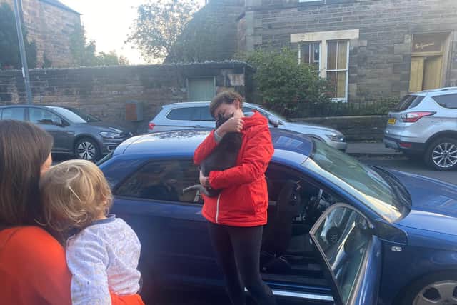Caron Cook clutching Buddy in her arms after he was found locked inside a car picture: supplied