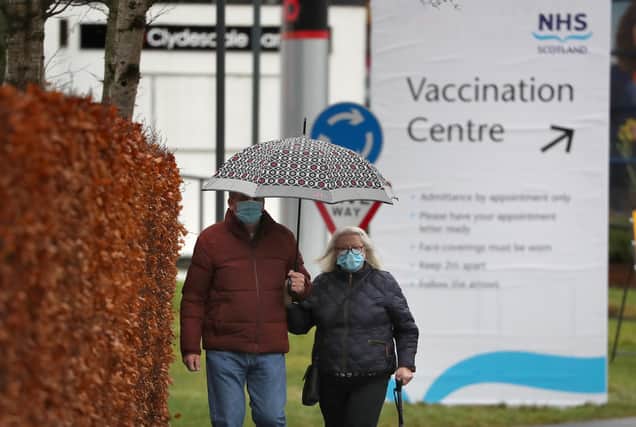 People walk passed a vaccination centre sign at the Royal Highland Centre in Edinburgh (Picture: Andrew Milligan/PA)