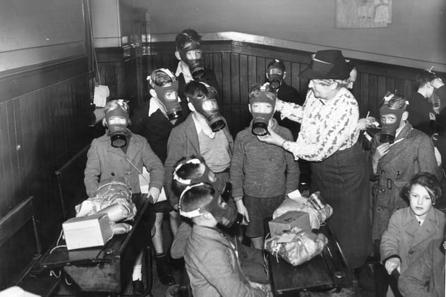 In preparation for bombing raids, children at South Bridge Primary are fitted with their gas masks on the 28th August 1939.