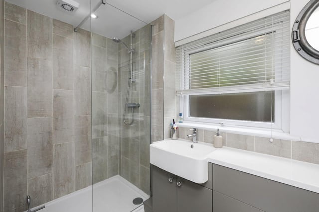 The stunning en-suite shower room with large double shower base, wc and sink with combined vanity unit and towel radiator.
