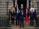 The full Cabinet assemble on the steps of Bute House, the First Minister's official residence, in Charlotte Square. 
First Minister Humza Yousaf is in the front and centre, with (left to right) on the back row: Angela Constance, Secretary for Justice and Home Affairs, Mairi McAllan, Secretary for Net Zero and Just Transition, Angus Robertson, Secretary for Constitution, External Affairs and Culture, Shirley-Anne Sommerville,  Secretary for Social Justice, and Mairi Geougeon, Secretary for Rural Affairs, Land Reform and Islands, and on the front row: Jenny Gilruth, Secretary for Education and Skills, Neil Gray, Secretary for Wellbeing, Economy, Fair Work and Energy, Shona Robinson, Deputy First Minister and Secretary for Finance and Michael Matheson, Secretary for NHS Recovery, Health and Social Care.