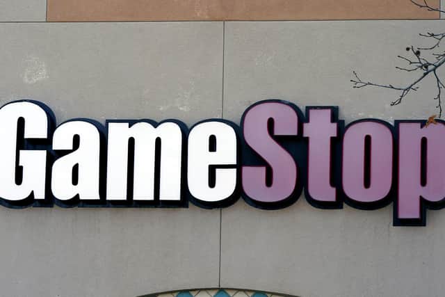 This Thursday, Jan. 28, 2021 photo shows a GameStop store sign in Dallas. The online trading platform Robinhood is moving to restrict trading in GameStop and other stocks that have soared recently due to rabid buying by smaller investors. GameStop stock has rocketed from below $20 to around $350 this month as a volunteer army of investors on social media challenged big institutions who has placed market bets that the stock would fall. (AP Photo/LM Otero)