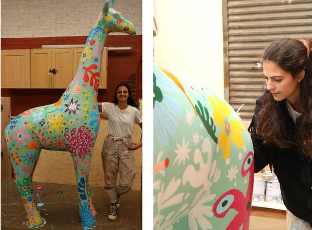 Artist Carolina Haraki paints a giraffe.