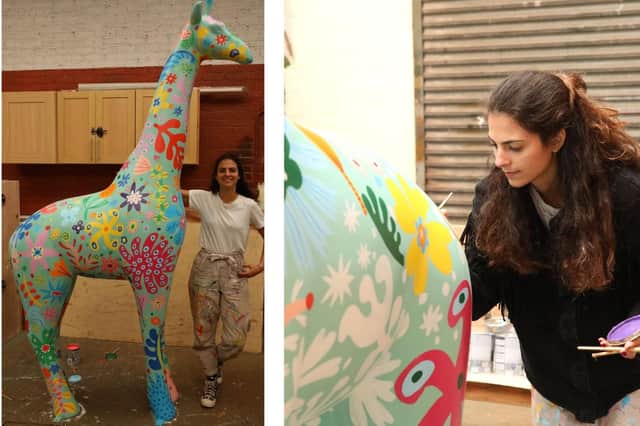 Artist Carolina Haraki paints a giraffe.
