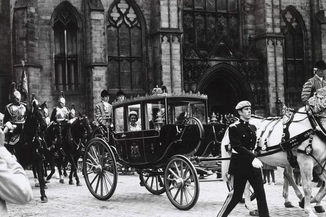 The Queen and the Duke of Edinburgh outside St Giles Cathedral in the state coach during the 1977 Silver Jubilee visit.
The Queen can be seen smiling inside the ceremonial carriage led by white horses, followed by a ceremonial cavalry regiment. Two footmen sit on the back of the carriage.