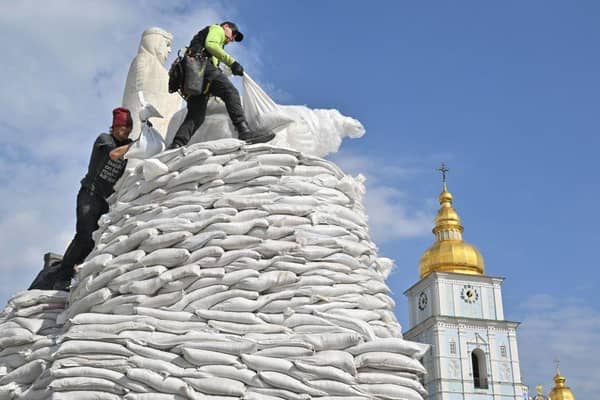 Volunteers assemble sand bags to cover and protect the Monument to Princess Olga, St. Andrew the Apostle and the educators Cyril and Methodius in Kyiv.