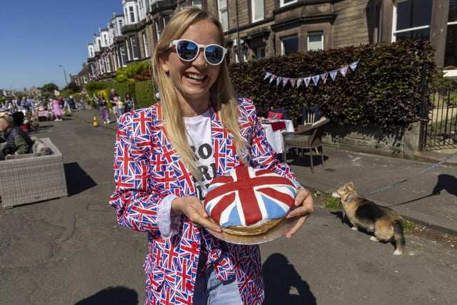A woman poses with a Union Jack flag cake as residents of Netherby Drive in Trinity celebrate the Platinum Jubilee. (Photo by Robert Perry/Getty Images)