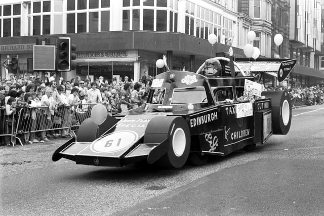 An Edinburgh taxi is dressed up as a racing car for the Evening News Festival Cavalcade. It can be seen here making its way down Princes Street. Year: 1983