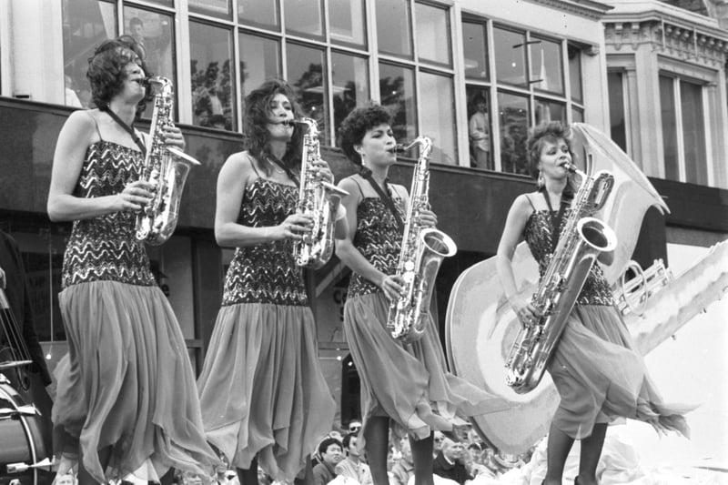 Members of The Fairer Sax, an all-girl saxophone band, take part in a windy Evening News Cavalcade in Princes Street Edinburgh, August 1989.