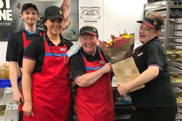 Isabel Allison receives flowers from her colleagues at Greggs Loanhead to mark her retirement.