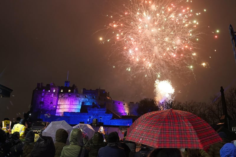 Revellers watch an early fireworks display at Edinburgh Castle in the run-up to the bells in Edinburgh. Picture: Andrew Milligan/PA Wire.