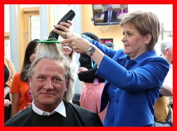 Nicola Sturgeon cuts the hair of David Torrance MSP for charity in September last year (Picture: Andrew Milligan/PA Wire)