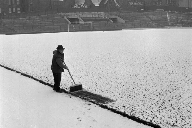 Head groundsman Matt Chalmers sweeps the snow off Tynecastle Football Ground in February 1964.