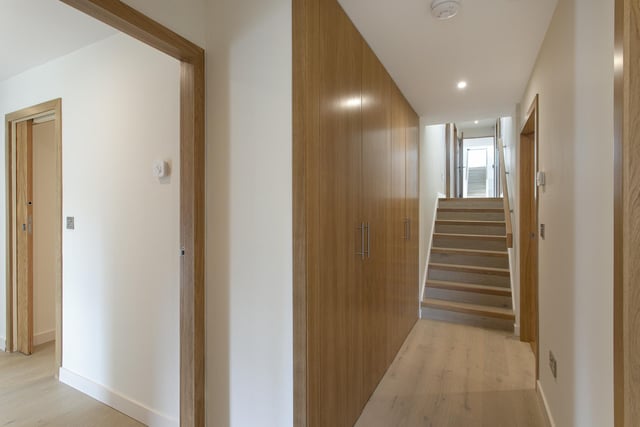 Returning back to the lower floor, a separate hallway affords access to the first of four bedrooms, a shower room, and a boot/utility room which supplements the kitchen and provides a discrete space for coats, shoes, and laundry appliances.