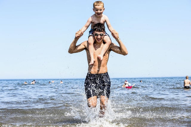Four-year old Lewis Walton splashes in the sea with his Uncle Pedro Jarvie