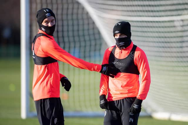 Hearts' two Australians Nathaniel Atkinson and Cameron Devlin try their best to wrap up warm during training. Picture: SNS