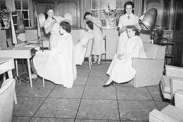 The hairdressers salon in Jenners could accommodate up to 10 clients. You can see three women here getting their hair done. Year: 1955