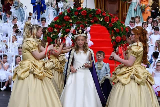 Queen Aimee Gilcrest walks through an archway of roses to be presented to the people of Bo'ness