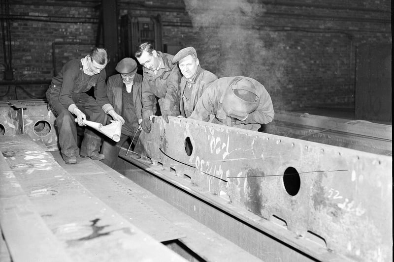 Men checking the plans for a hopper before welding, 1958.