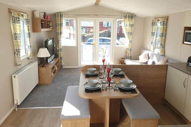 Open plan living with kitchens and lounge areas and french doors onto decking.