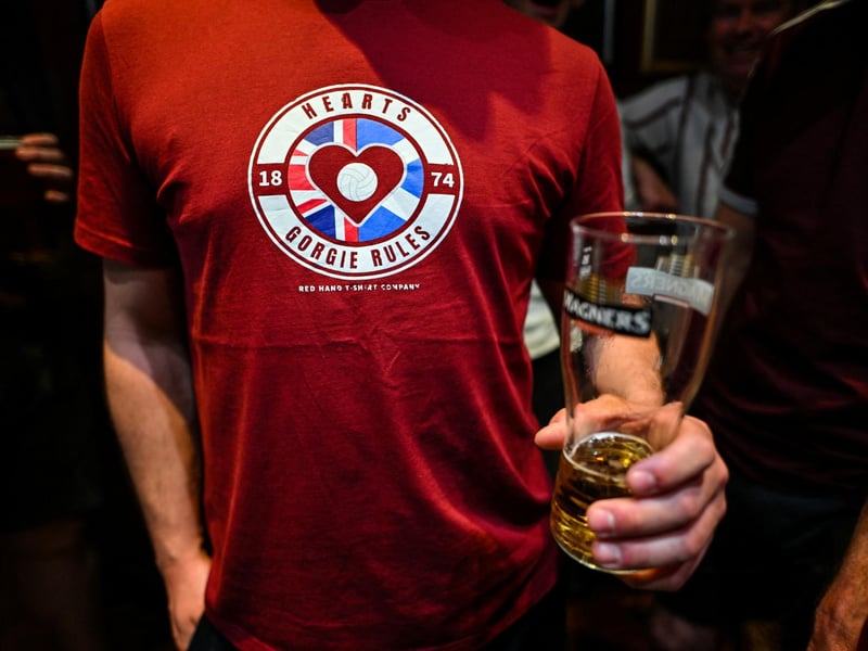A Hearts fan has pre-match drinks (Photo by ANDY BUCHANAN / AFP via Getty Images)