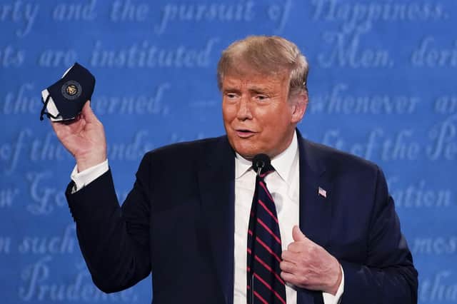 Donald Trump holds up his face mask during the first presidential debate with Joe Biden, shortly before the US President was diagnosed with Covid-19 (Picture: Julio Cortez/AP)