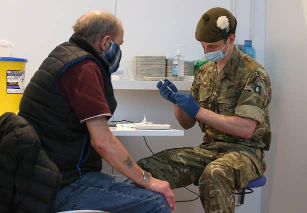 Military doctor Captain Robert Reid prepares to administer a Covid-19 vaccine to Edinburgh resident Derek Fraser at the temporary vaccination centre set up at the Royal Highland Showground (Picture: Andrew Milligan/pool/AFP via Getty Images)