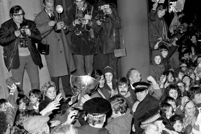 Police hold back Hibs fans as Pat Stanton struggles through the crowds with the League Cup trophy
