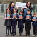 Local Taylor Wimpey Sales Executive Laura Colandrea with headteacher Mrs Mouat, headteacher and class members of Primary 3 at Mauricewood
Primary School celebrating their donation of £250 and Ecotastic Activity books.