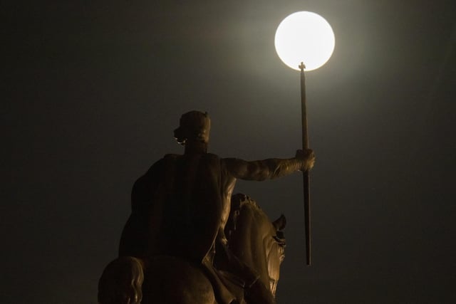 A supermoon rises behind sculpture of Tomislav of Croatia, the first Croatian king, in downtown Zagreb, Croatia, Tuesday, June 14, 2022.  (AP Photo/Darko Bandic)