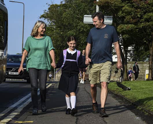 Parents Mairi and Tom Cowley walk their daughter Lilyanna to Flora Stevenson Primary School as she starts P5 after five months out of the classroom