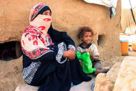 A Yemeni woman sits with a child at a makeshift camp for the internally displaced in the northern Hajjah province, on March 6, 2022. - Yemen's women and girls are bearing the brunt of a seven-year civil war that has robbed many of their freedoms, experts say (Photo by ESSA AHMED / AFP) (Photo by ESSA AHMED/AFP via Getty Images)