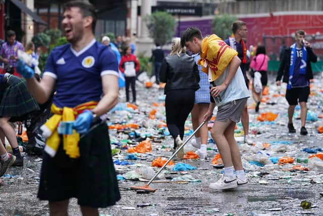 Scotland fans clean up litter in Leicester Square (Pic: Kirsty O'Connor/PA Wire)